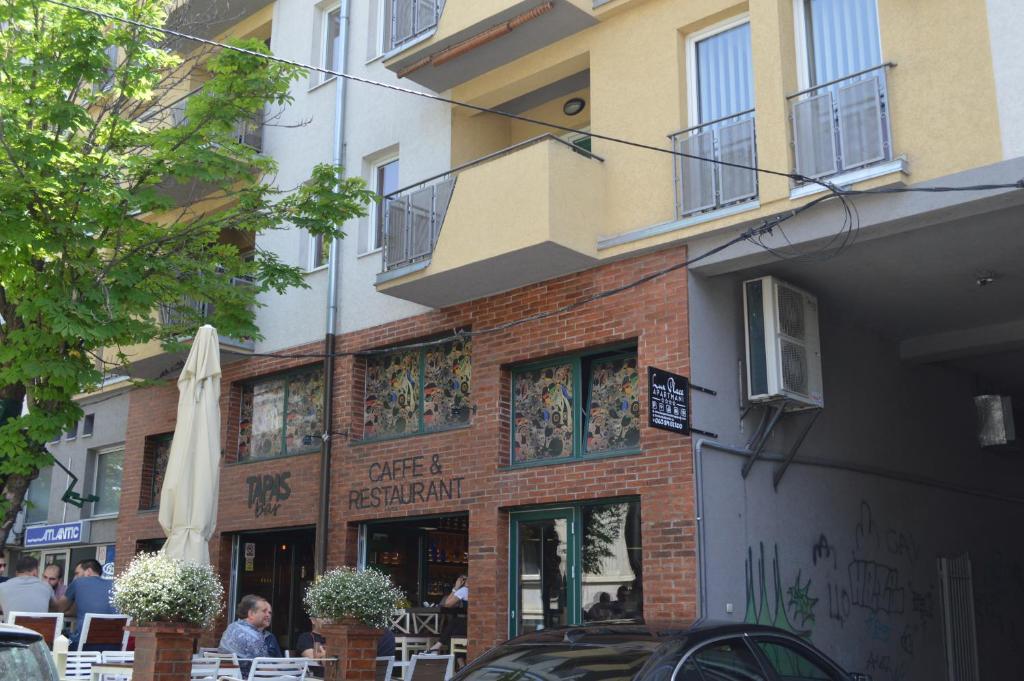 a brick building with a pizza restaurant on a street at Lux Place Apartments Downtown in Kragujevac