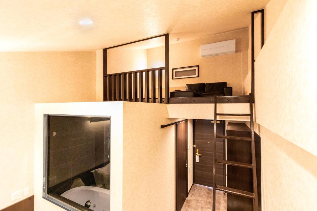 a small apartment with a staircase and a bathroom at Kerama Terrace in Tokashiki