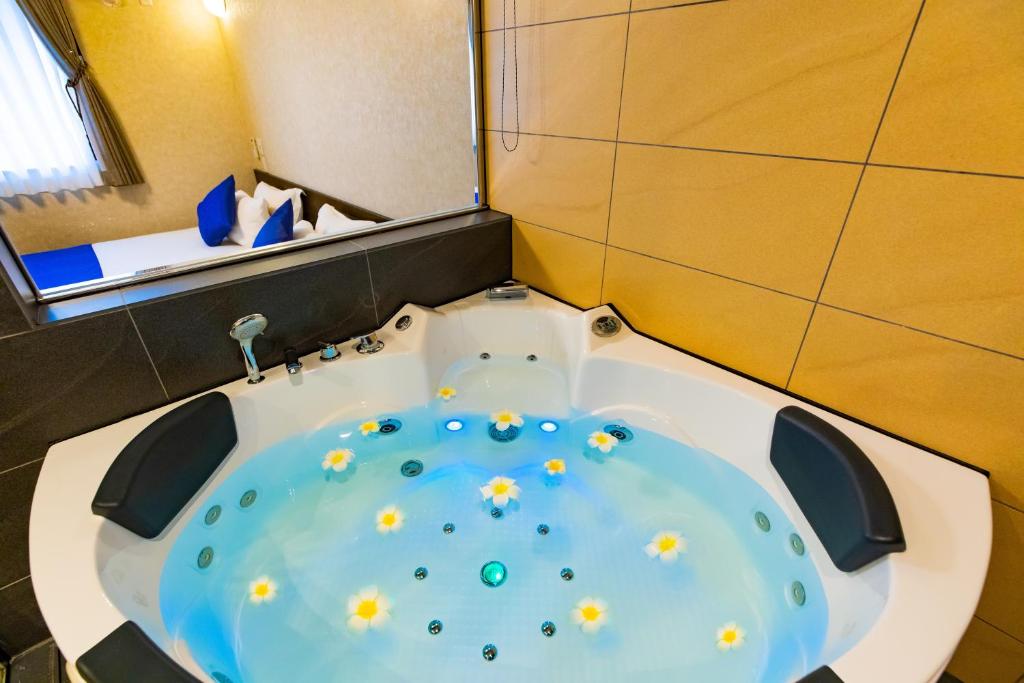 a bathroom with a tub with yellow flowers in it at Kerama Terrace in Tokashiki