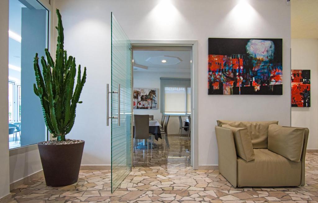a living room with a couch and a potted plant at Hotel Bristol in Caorle