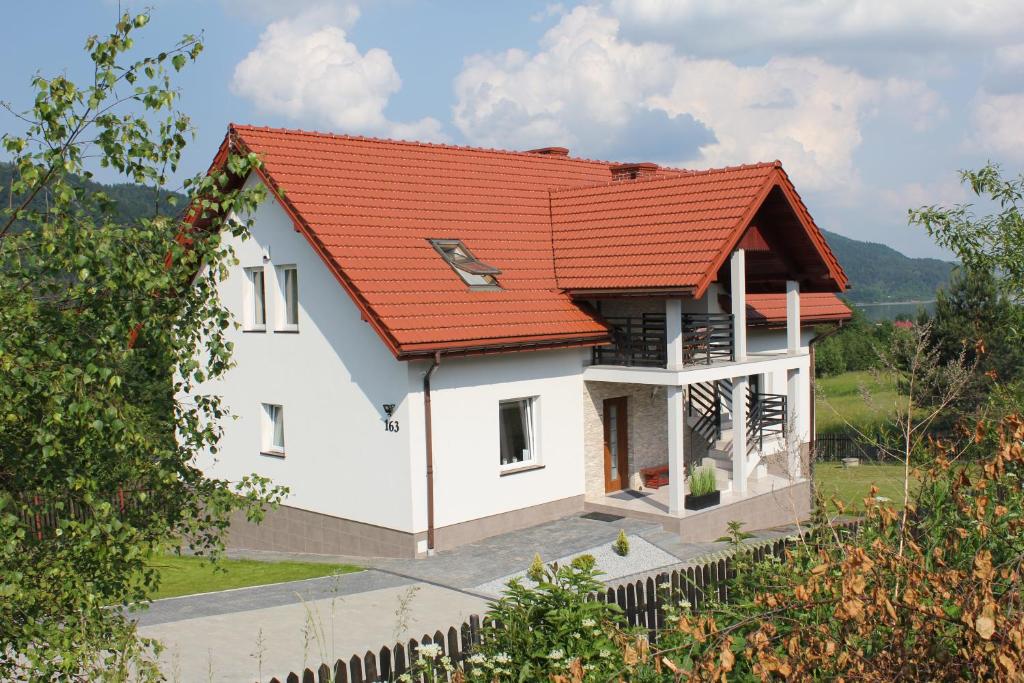 a white house with an orange roof at Pokoje Gościnne 4 Pory Roku in Klimkówka