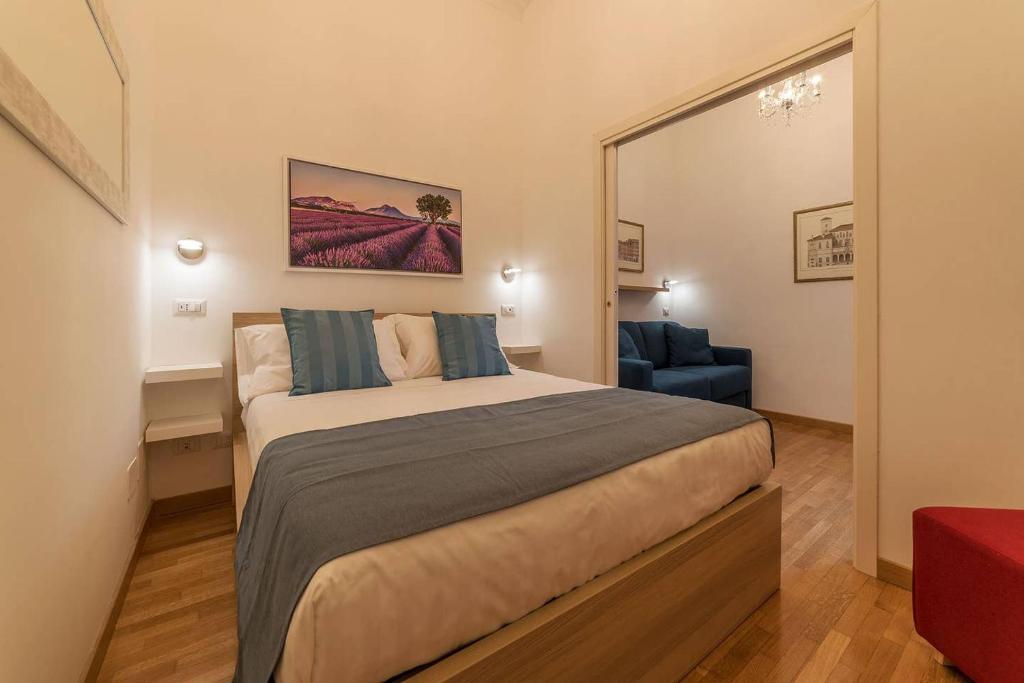 um quarto com uma cama grande e uma cadeira azul em CS Termini Nazionale Apartments em Roma