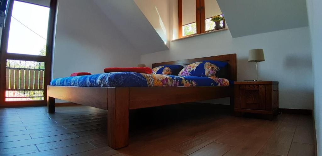 Bett mit blauer Decke in einem Zimmer in der Unterkunft Zagroda Jakubka in Myszyniec