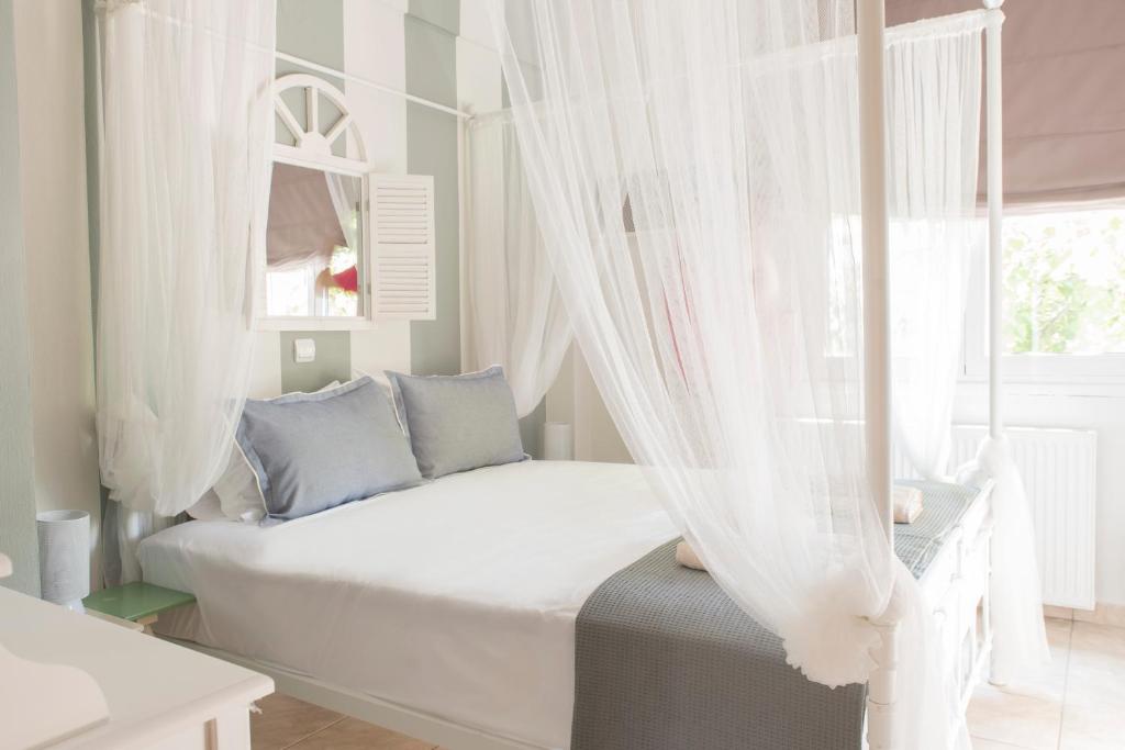 1 dormitorio con 1 cama con cortinas y ventana en Ikies Luxury Apartments, en Ofrinion