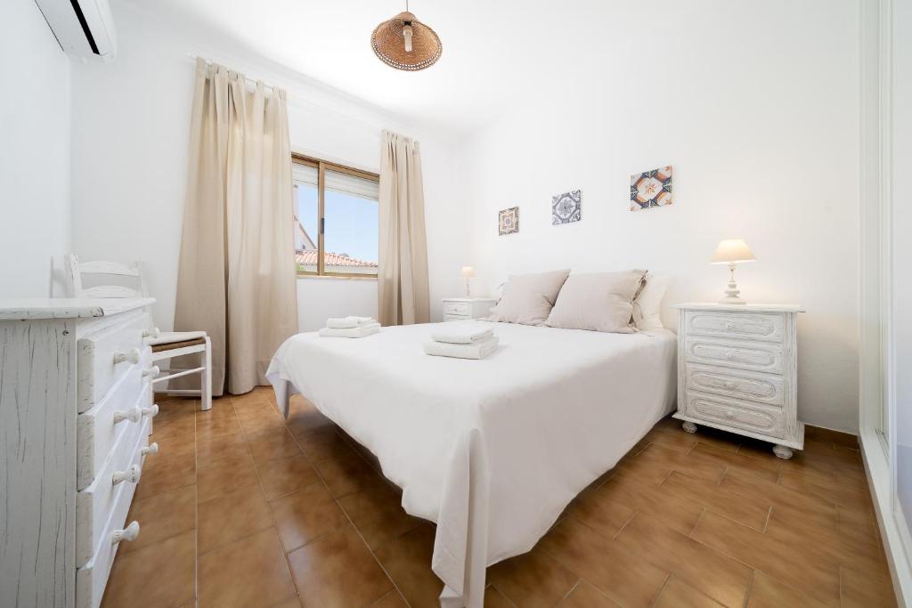 een witte slaapkamer met een groot wit bed en een dressoir bij Casa Mar in Carvoeiro