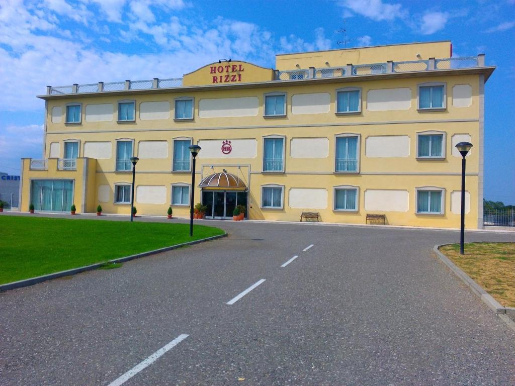 a yellow hotel with a road in front of it at Hotel Rizzi in Castel San Giovanni