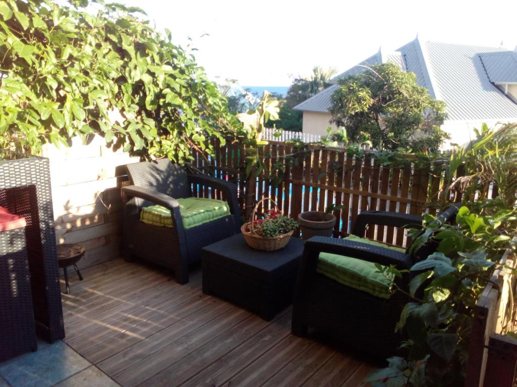 un patio con sillas y plantas en una terraza en STUDIO MI AIME AOU, en La Saline-Les-Bains