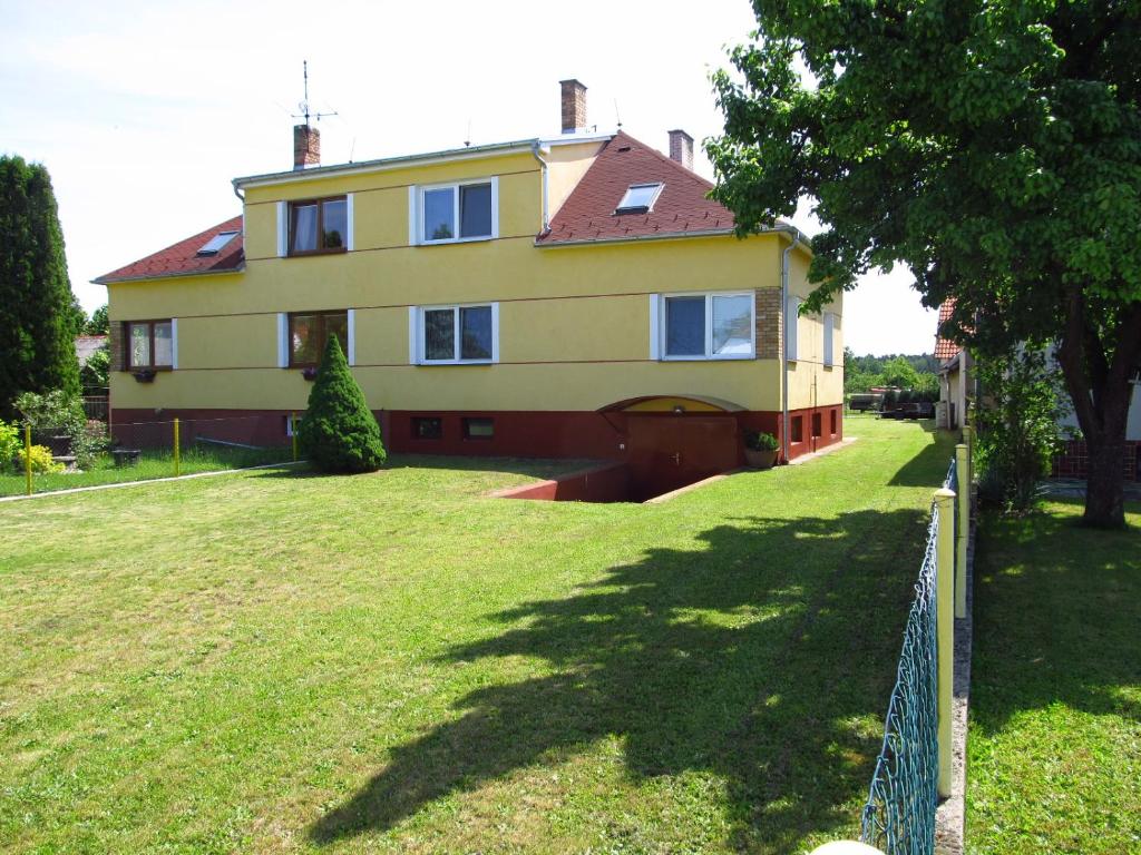 una gran casa amarilla con una valla en el patio en Holiday Home U Čápů, en Lomnice nad Lužnicí