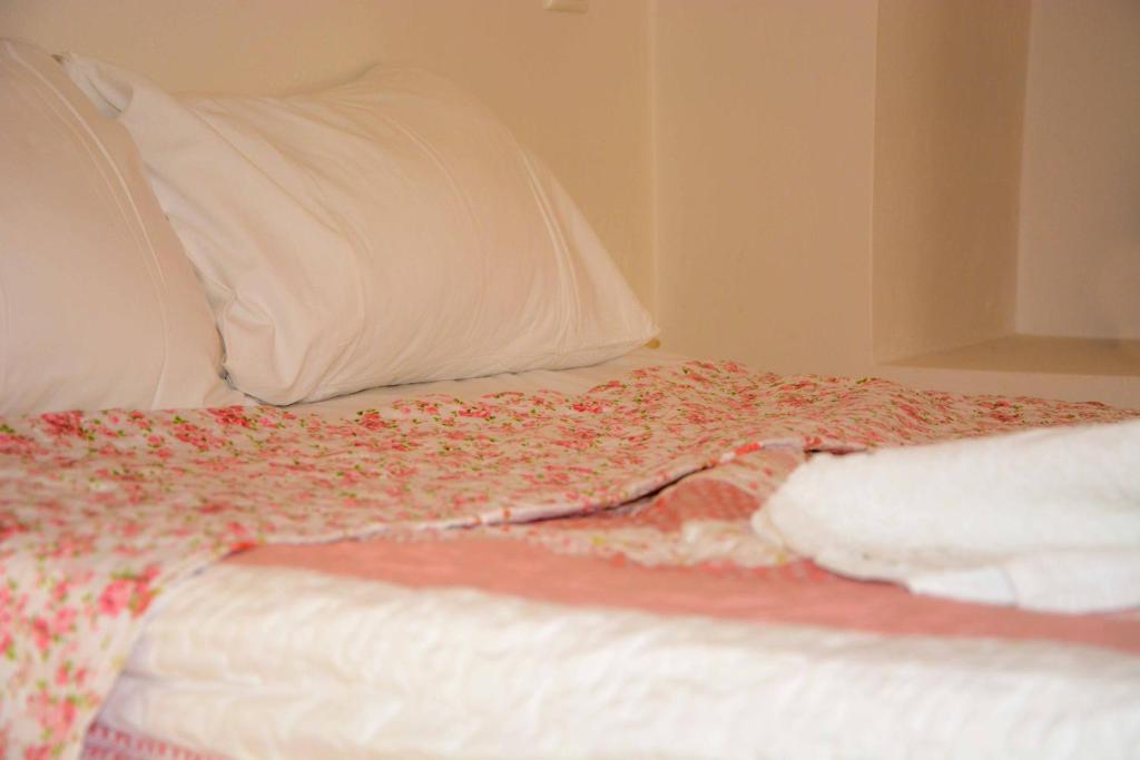 a bed with a white pillow and a blanket at Kleio House in Astypalaia Town