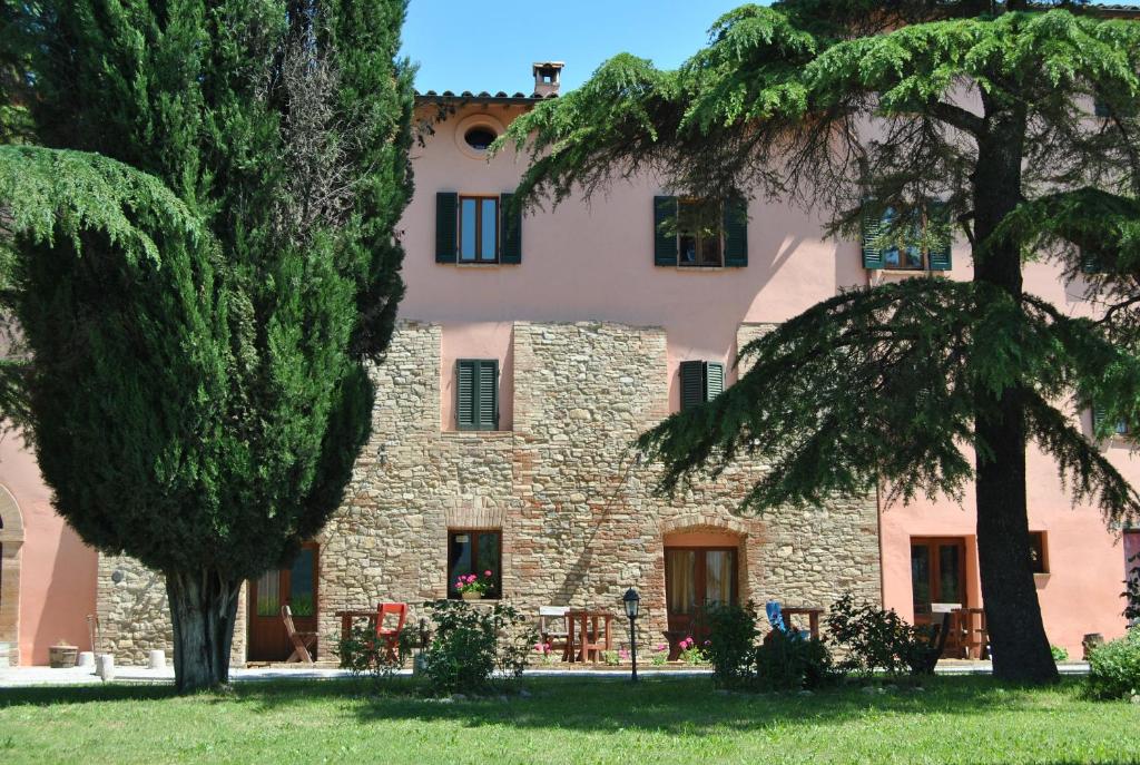 un antiguo edificio de piedra con árboles delante de él en Il Moro Country House, en Sant'Orfeto