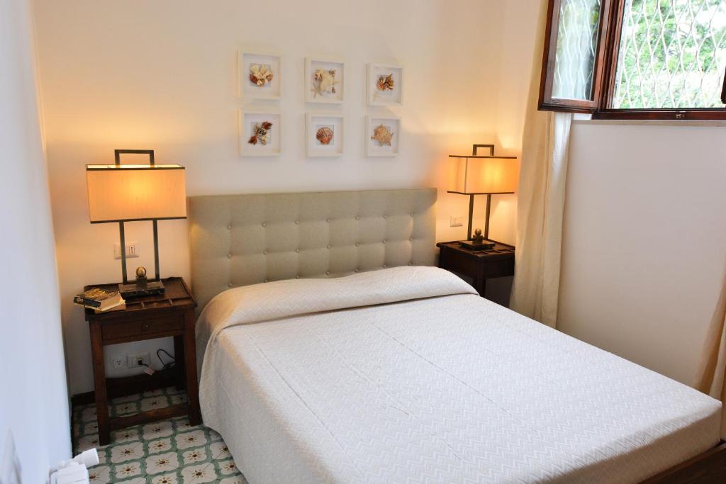 a bedroom with a white bed and two lamps at Luna Caprese Guest House in Anacapri