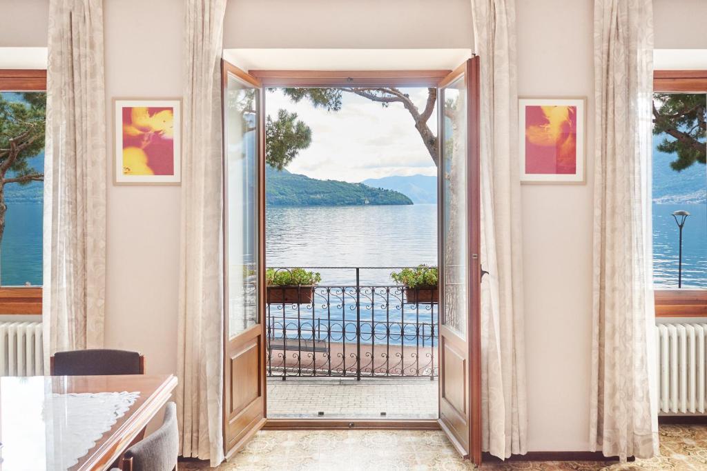 a door to a balcony with a view of the water at Residence Domaso - Esperienza in Centro Storico "Casa del Dottore" in Domaso