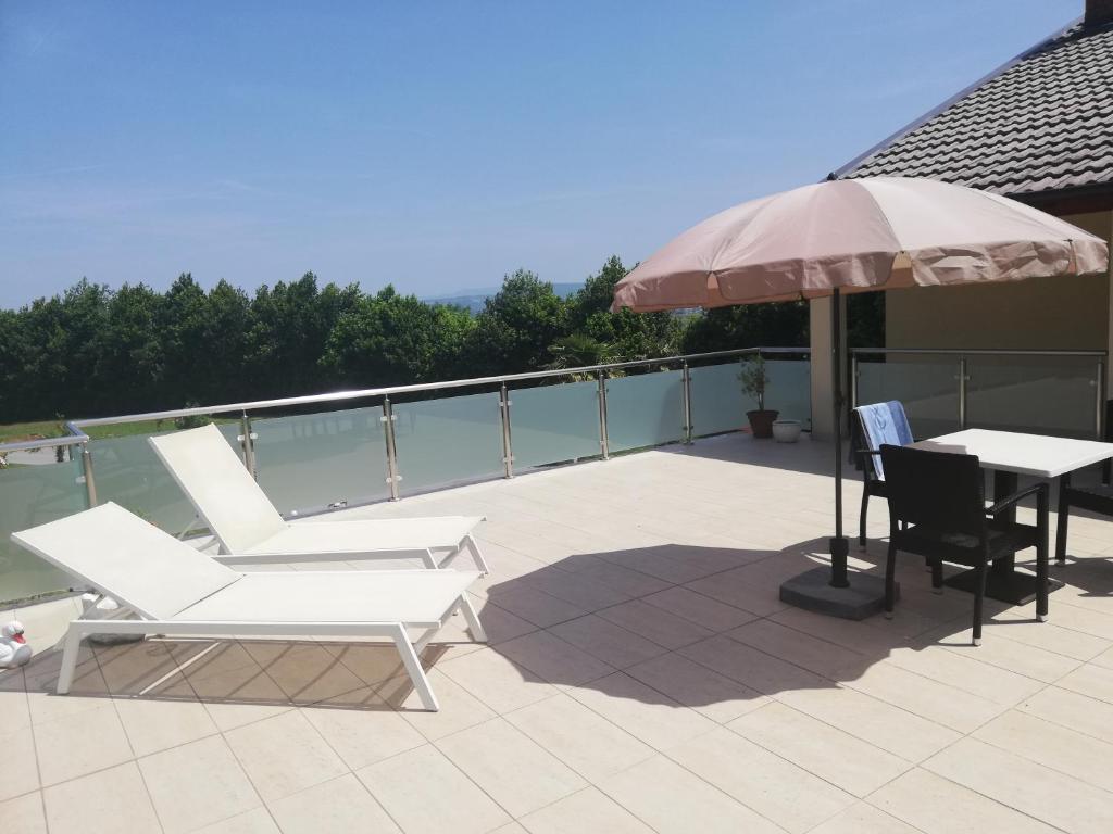 a patio with a table and two chairs and an umbrella at Studio ELLI KOPER in Koper