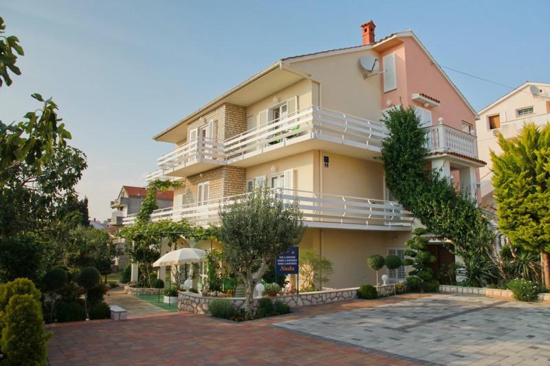 a large apartment building with a large balcony at F• R• I• E• N• D• S• in Novalja