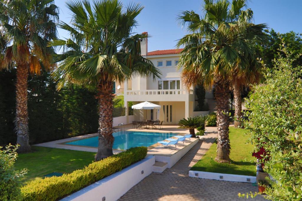 una casa con palme e una piscina di Luxury Villa Anavissos ad Anávissos
