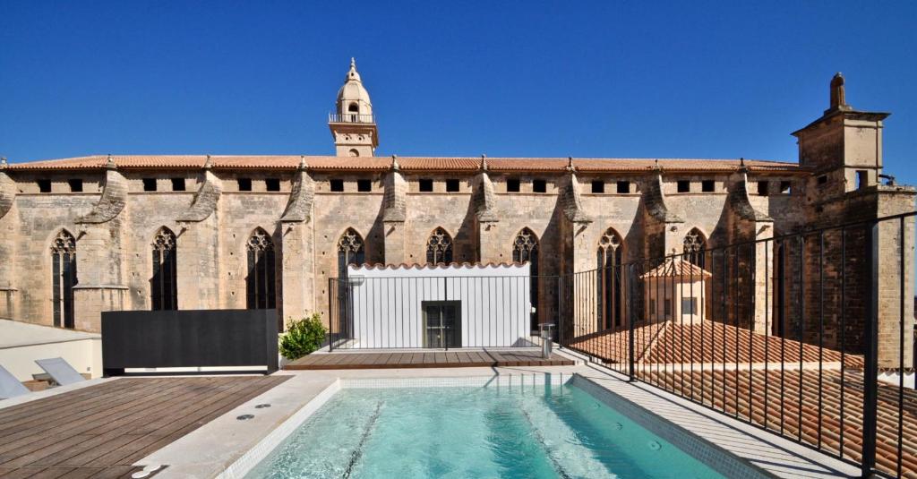 an external view of a building with a swimming pool at Hotel Basilica in Palma de Mallorca