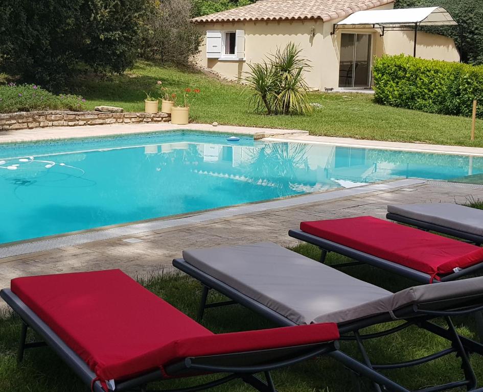 a swimming pool with two lounge chairs next to it at Chevalier in Saint-Nazaire