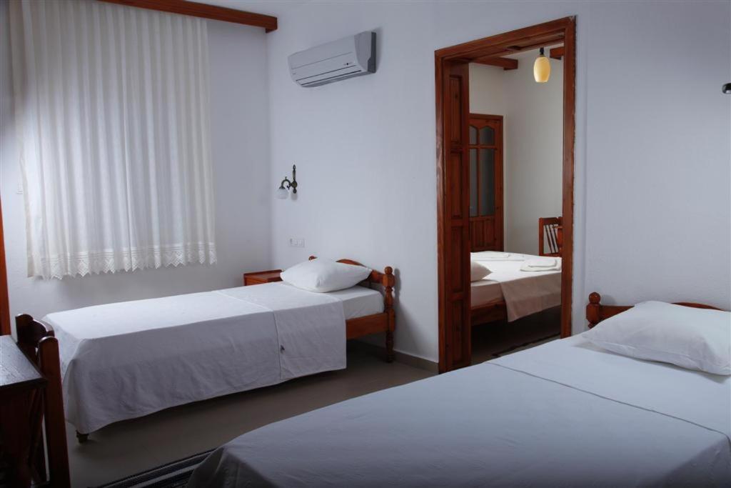 a hotel room with two beds and a mirror at Apollon Hotel in Patara
