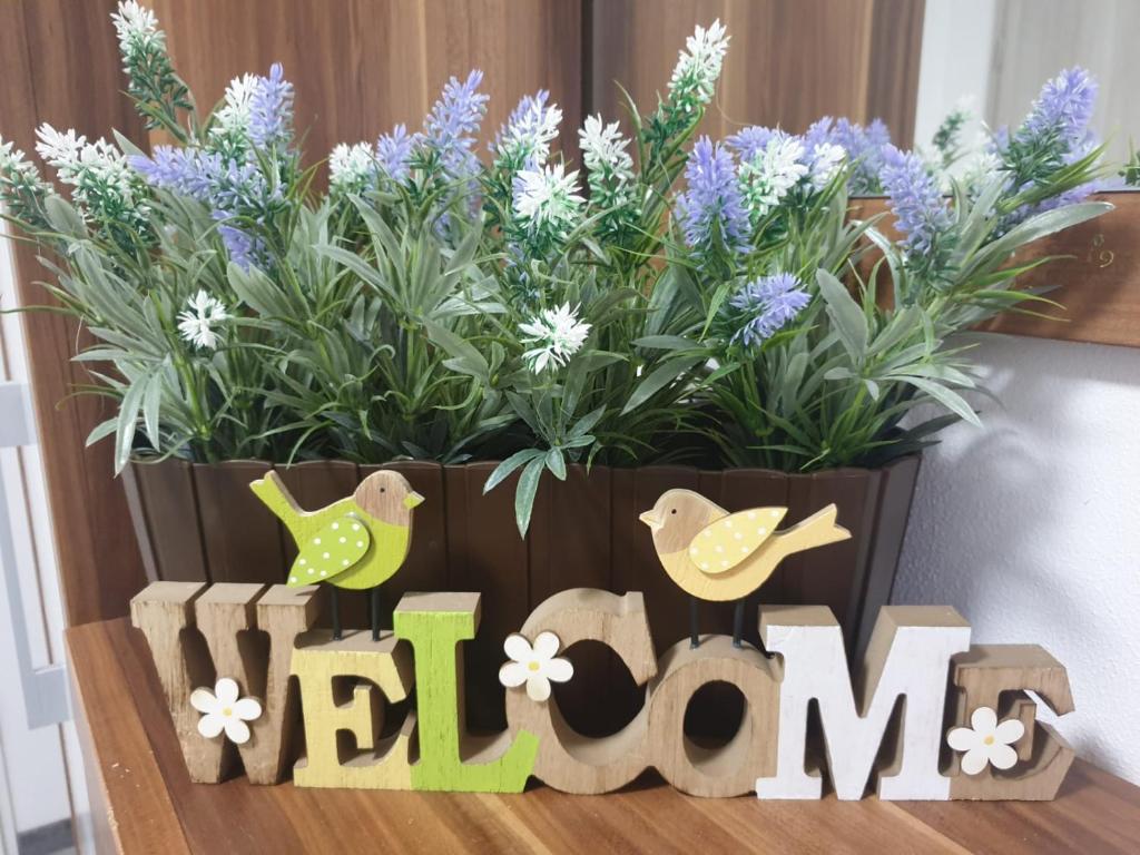 a potted plant with purple flowers and a sign that reads bloom at Komfortable Ferienwohnung in Waghäusel