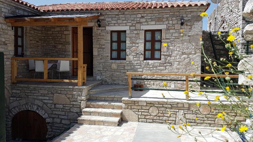 a stone house with a porch and stairs in front of it at Holiday Villa Old Qeparo in Qeparo