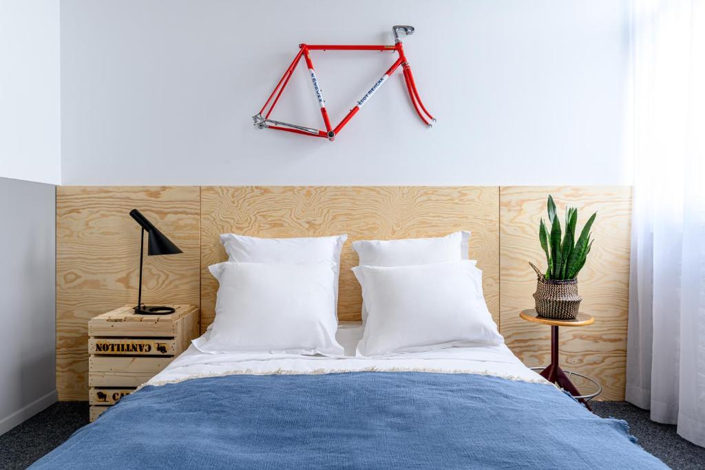 a bed with white pillows and a hanger above it at Hotel La Grande Cloche in Brussels