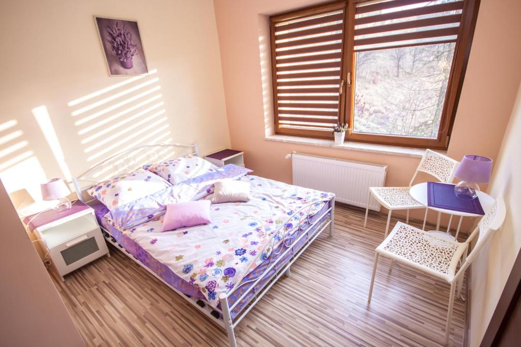 1 dormitorio con 1 cama, 2 sillas y ventana en Willa Potoczki en Istebna