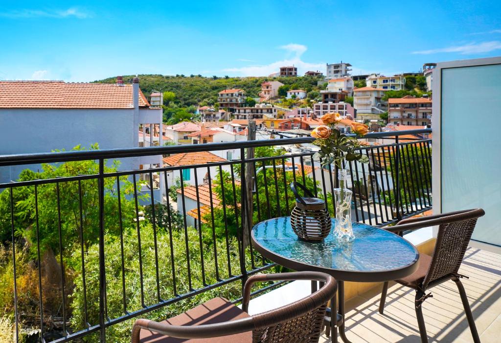 a balcony with a table with a vase of flowers on it at Theodore Apartments in Skala Marion