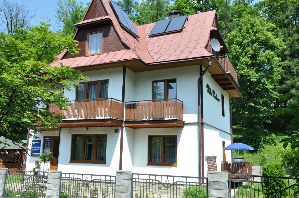 a large white house with a red roof at Willa Parkowa in Szczawnica