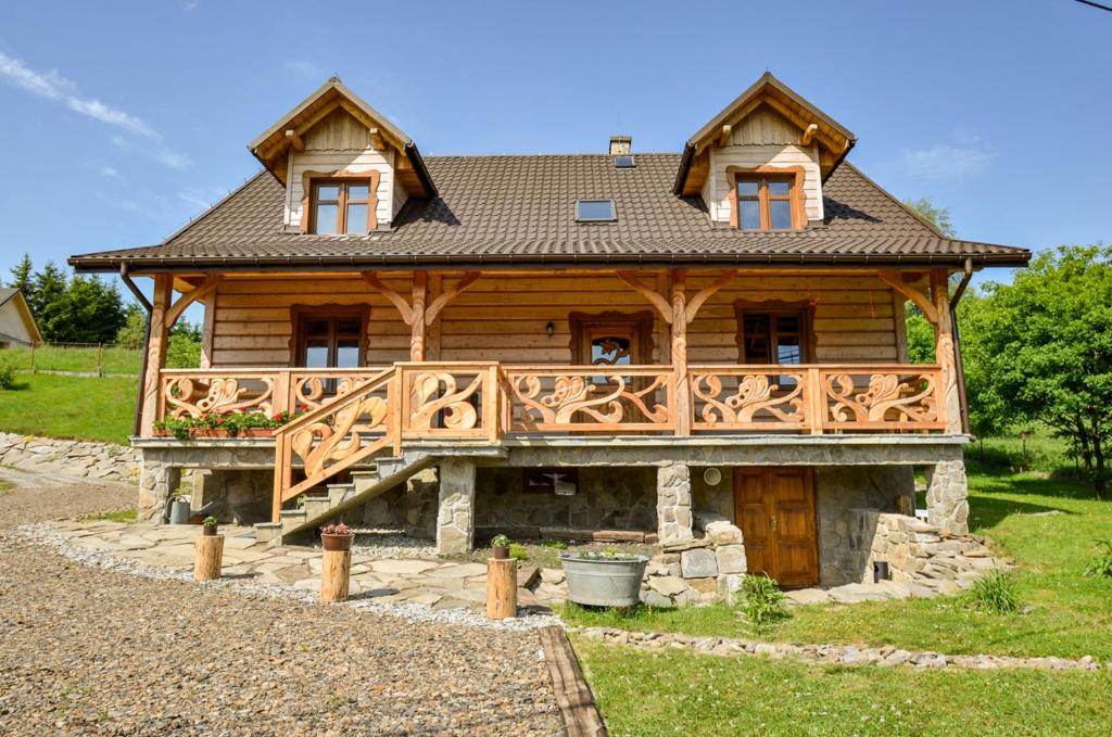 a log cabin with a deck and a porch at Dom Gościnny BIERWIONO in Cisna