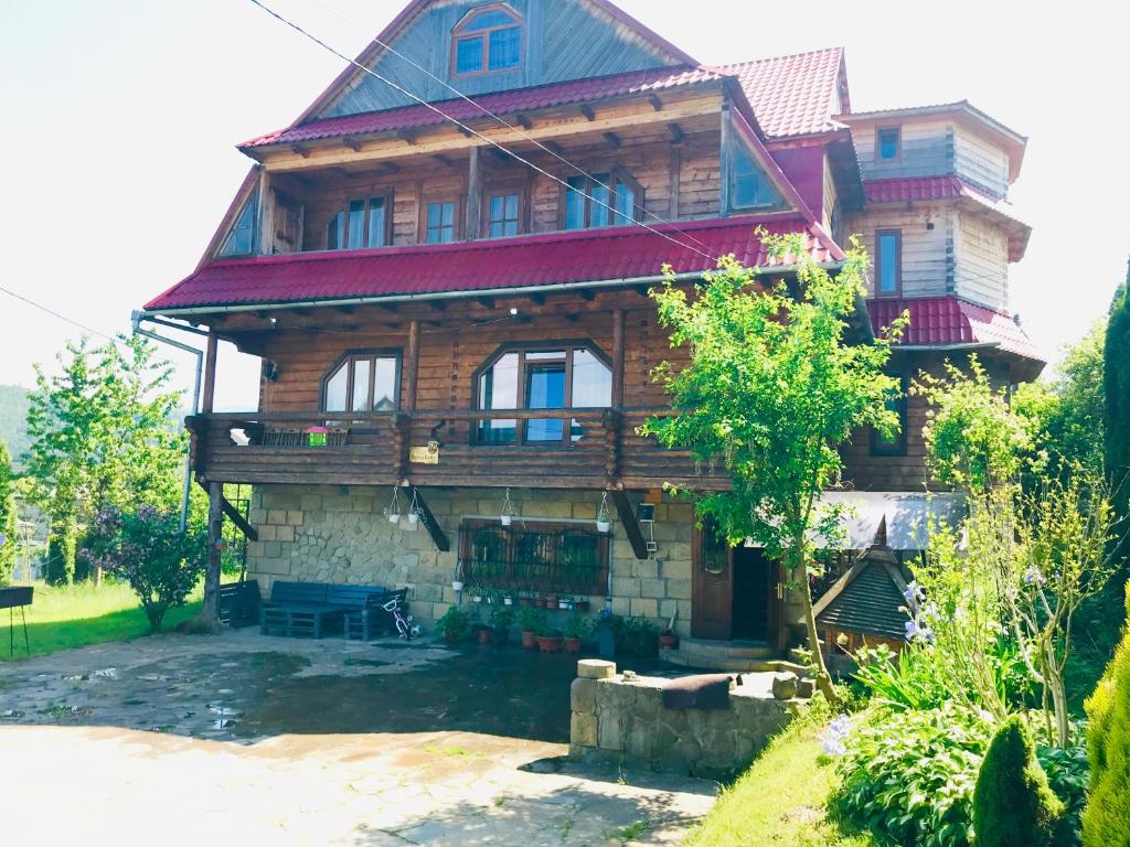 una gran casa de madera con techo de gambrel en Садиба Червона калина Private estate Chervona Kalyna, en Yaremche