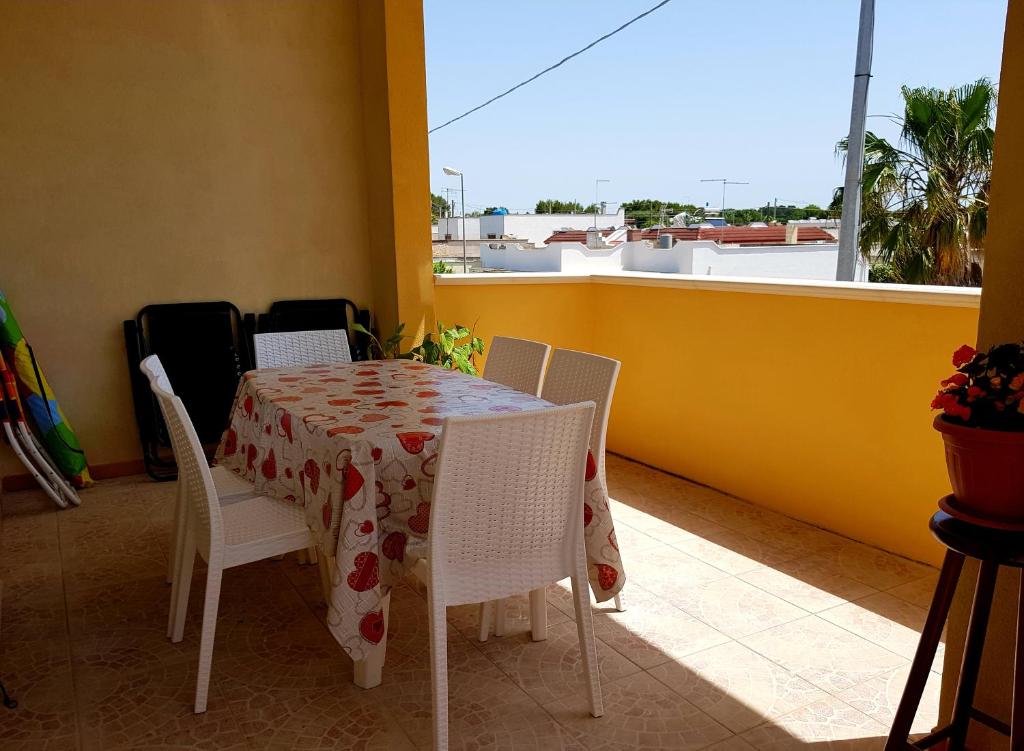 un tavolo e sedie su un balcone con tavolo e finestra di Casa Limone a San Pietro in Bevagna