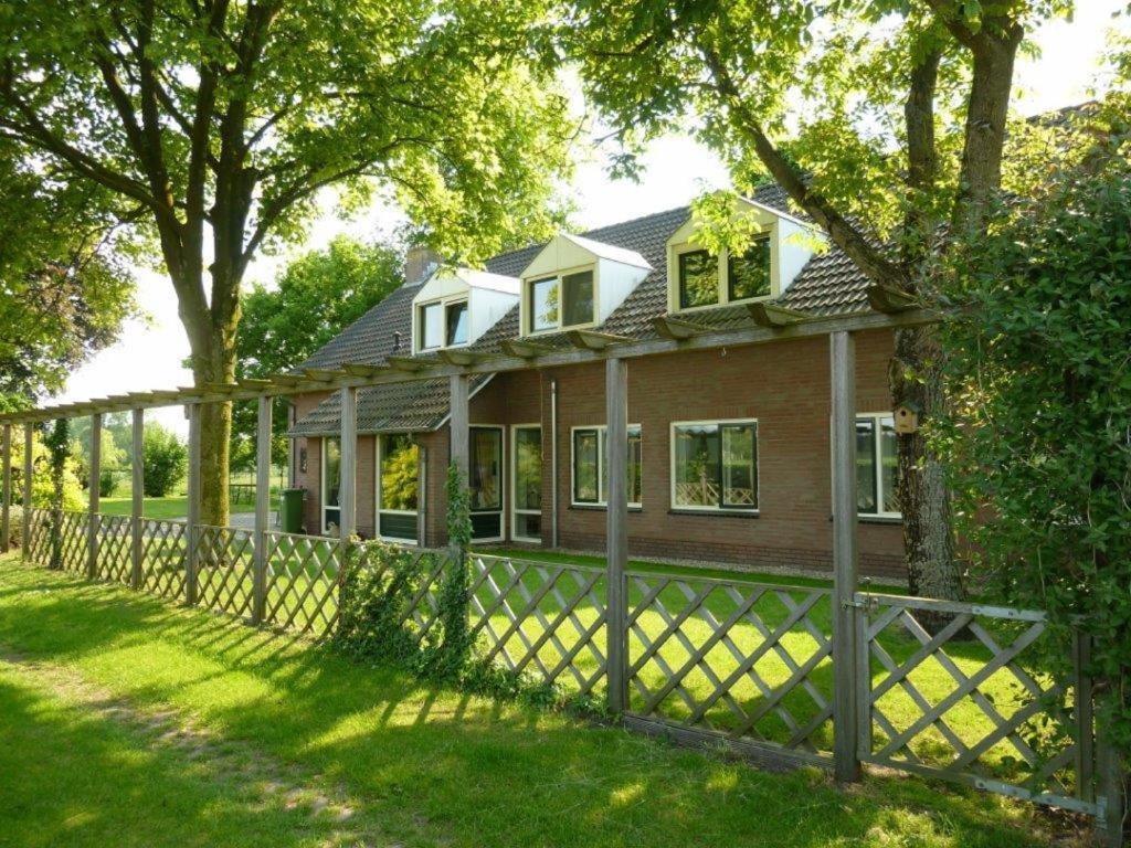 a house with a fence in the yard at Bed en Breakfast Boekel in Boekel