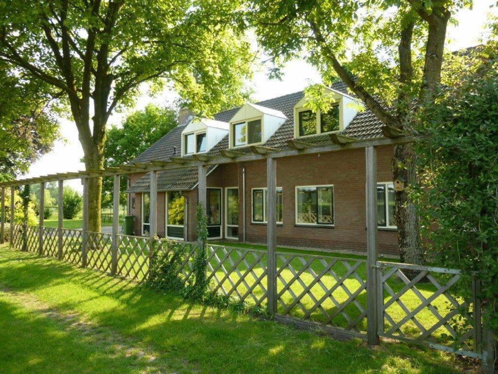 een huis met een hek in de tuin bij Bed en Breakfast Boekel in Boekel