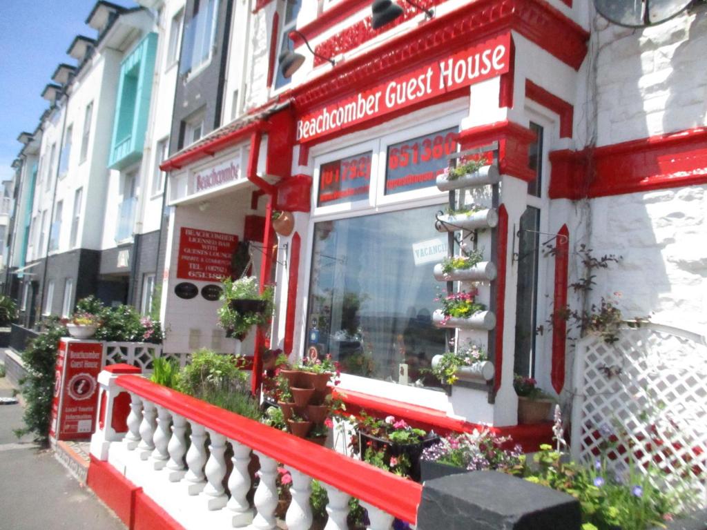 a red and white storefront of a grocery guest house at Beachcomber in Swansea