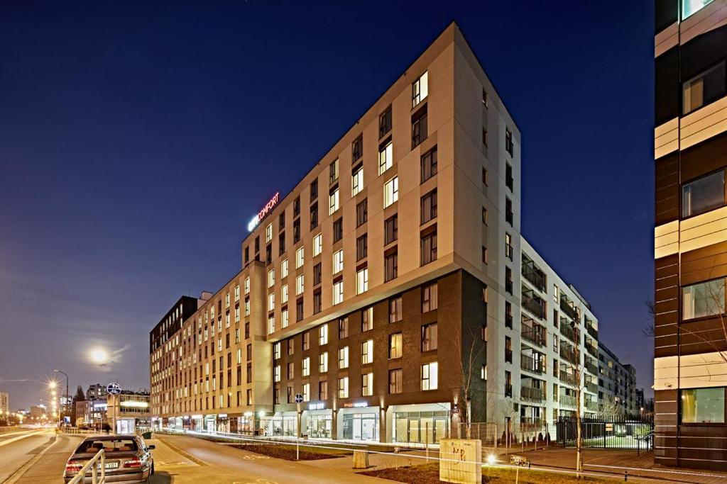 een hoog gebouw in een stadsstraat 's nachts bij Apartments "Wolska Residence" in Warschau