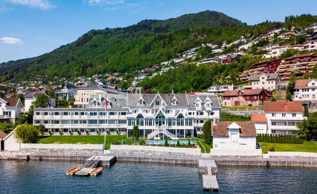 un grand bâtiment sur l'eau dans une ville dans l'établissement Hofslund Fjord Hotel, à Sogndal