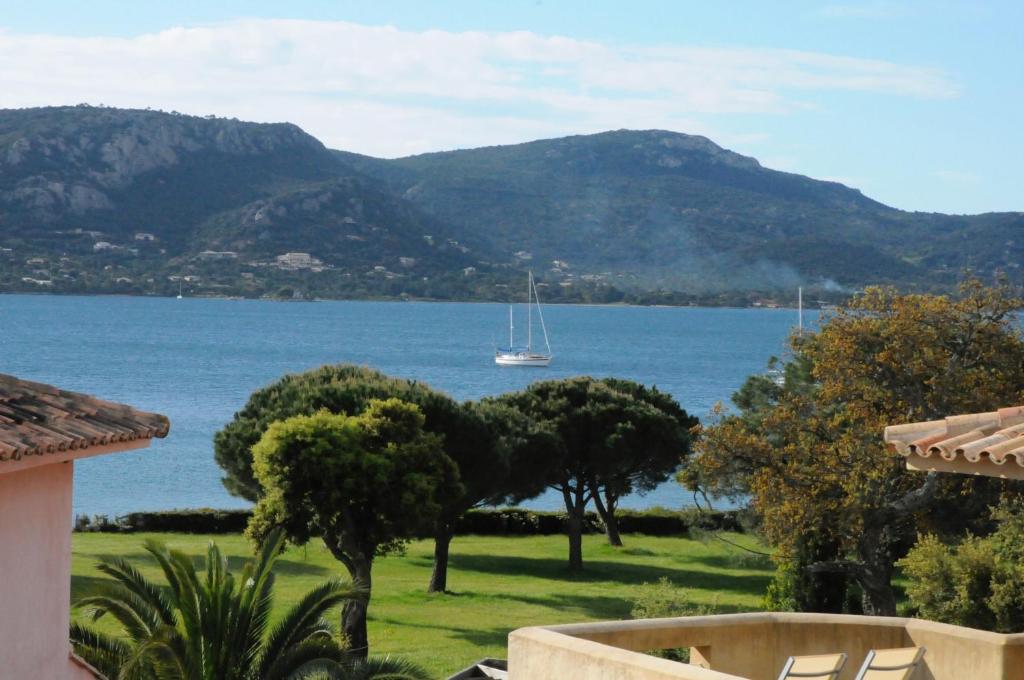 vistas a un lago con un barco en el agua en Appartement 2 pièces Pied dans l'eau en Porto Vecchio