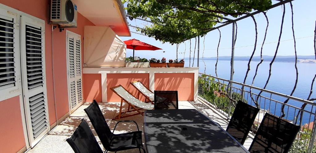 una mesa y sillas en un balcón con vistas al agua en Apartments KK, en Celina