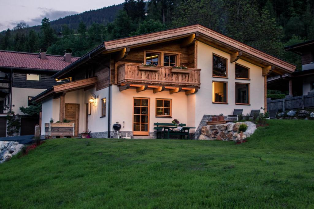 a large house with a balcony on top of a yard at Tauernwelt-Das AlpenNatur Chalet in Bruck an der Großglocknerstraße