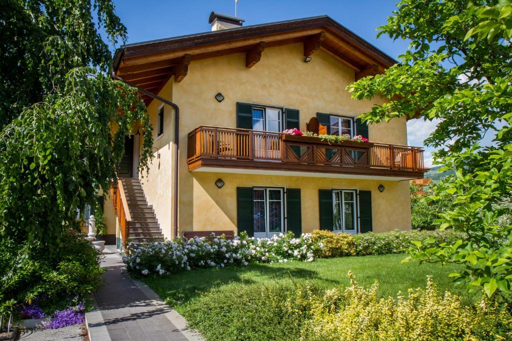 a house with a balcony with flowers on it at Agritur Val d'Adige in Trento