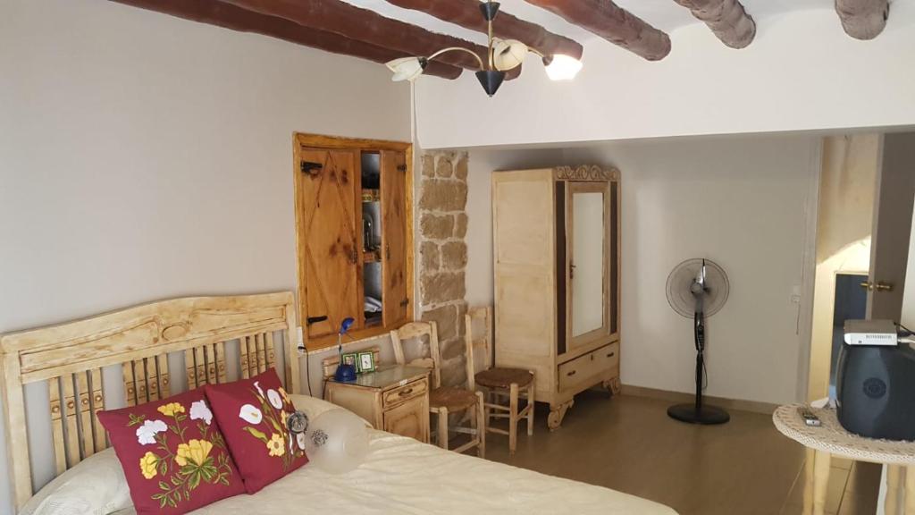1 dormitorio con cama, escritorio y espejo en Casa Larrosa rural en Sierra de Guara, en Sieso de Huesca