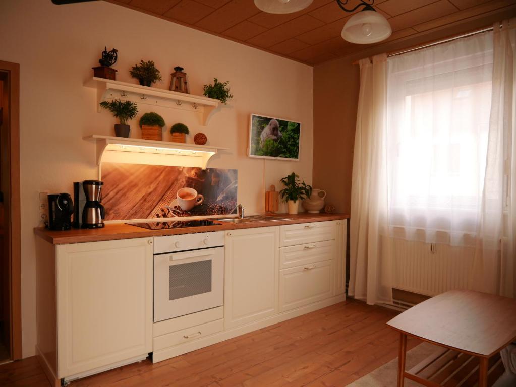 eine Küche mit weißen Schränken und einem Herd in der Unterkunft Ferienwohnung Wusterwitz in Wusterwitz