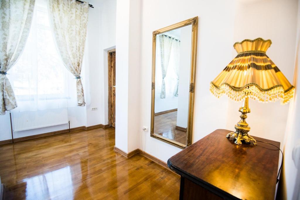 a lamp on a table in a room with a mirror at Writer s street residence in Arad