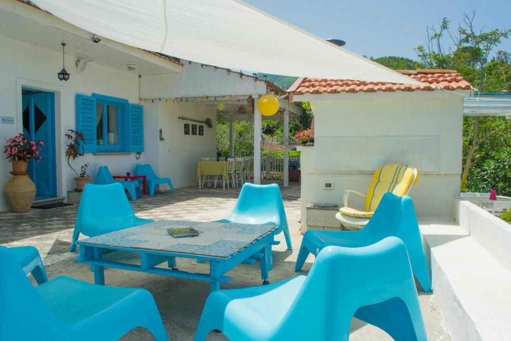 a patio with blue chairs and a table at Benvenuti Nel Sud in Sessa Cilento