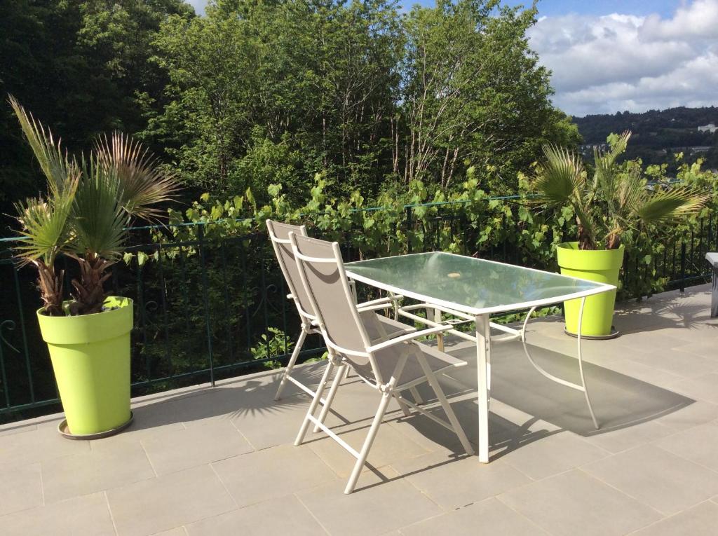 a table and chairs on a patio with potted plants at Suite panoramique à Tulle in Tulle