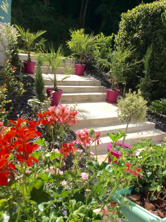 a garden with potted plants and flowers on steps at Suite panoramique à Tulle in Tulle