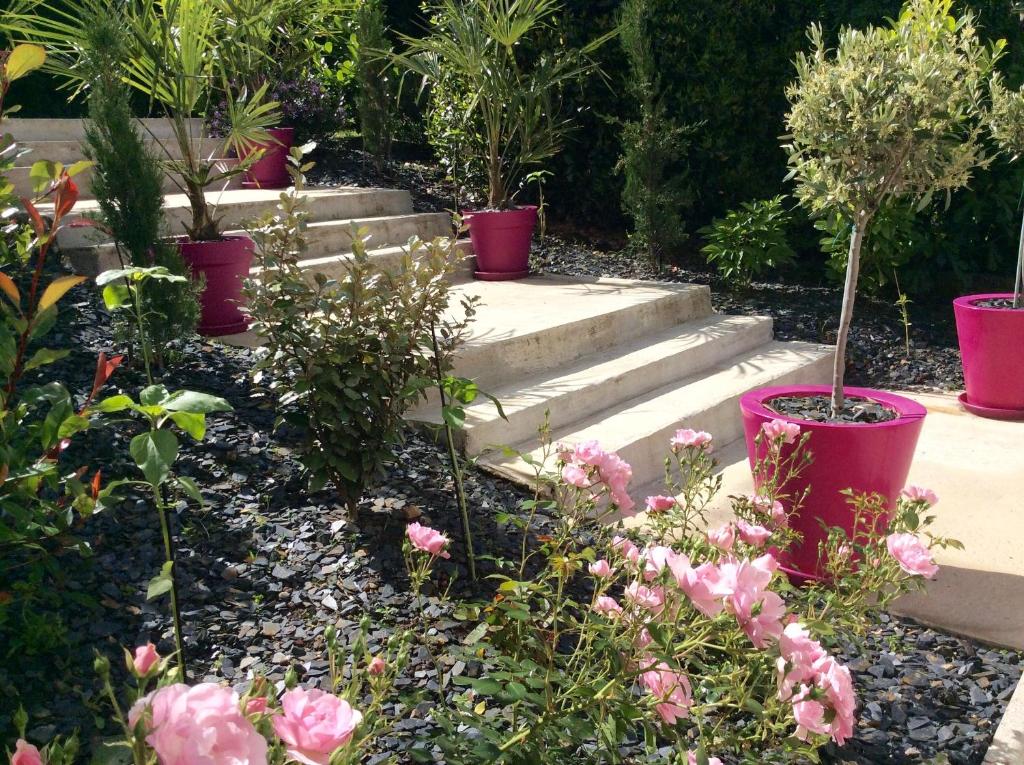 a garden with pink flowers and concrete steps at Suite panoramique à Tulle in Tulle