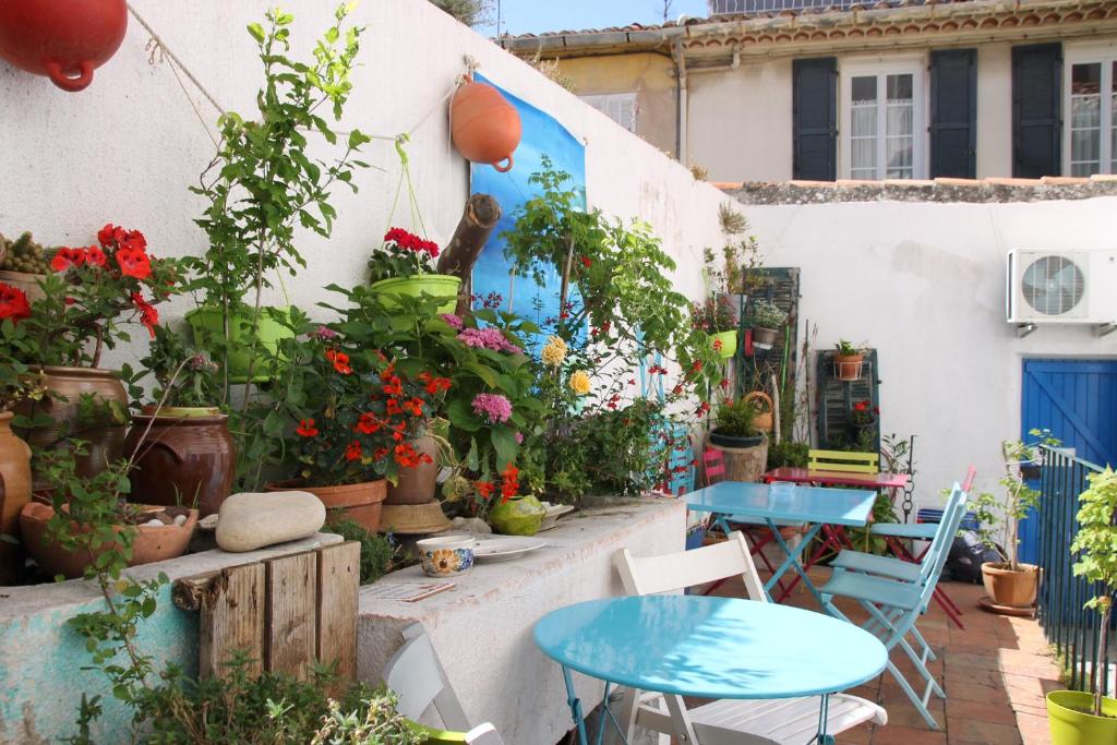 um pátio com duas mesas e vasos de plantas em Au Petit chez Soi em Cassis