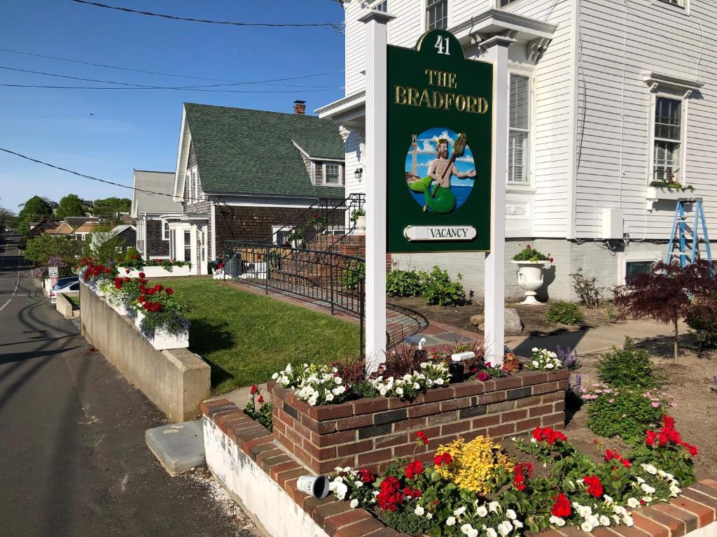 un cartel en un lecho de flores frente a una casa en The Bradford, en Provincetown