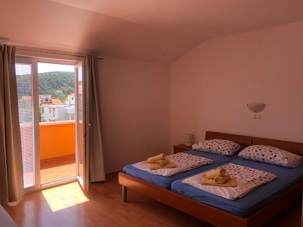 a bedroom with two beds and a large window at Apartment Laura in Lopar